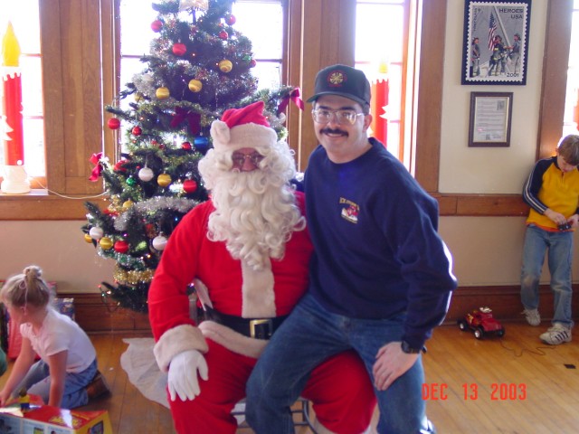 December 2003 - Chief Taylor placing his order with Santa for a new pumper, aerial platform, and fire station